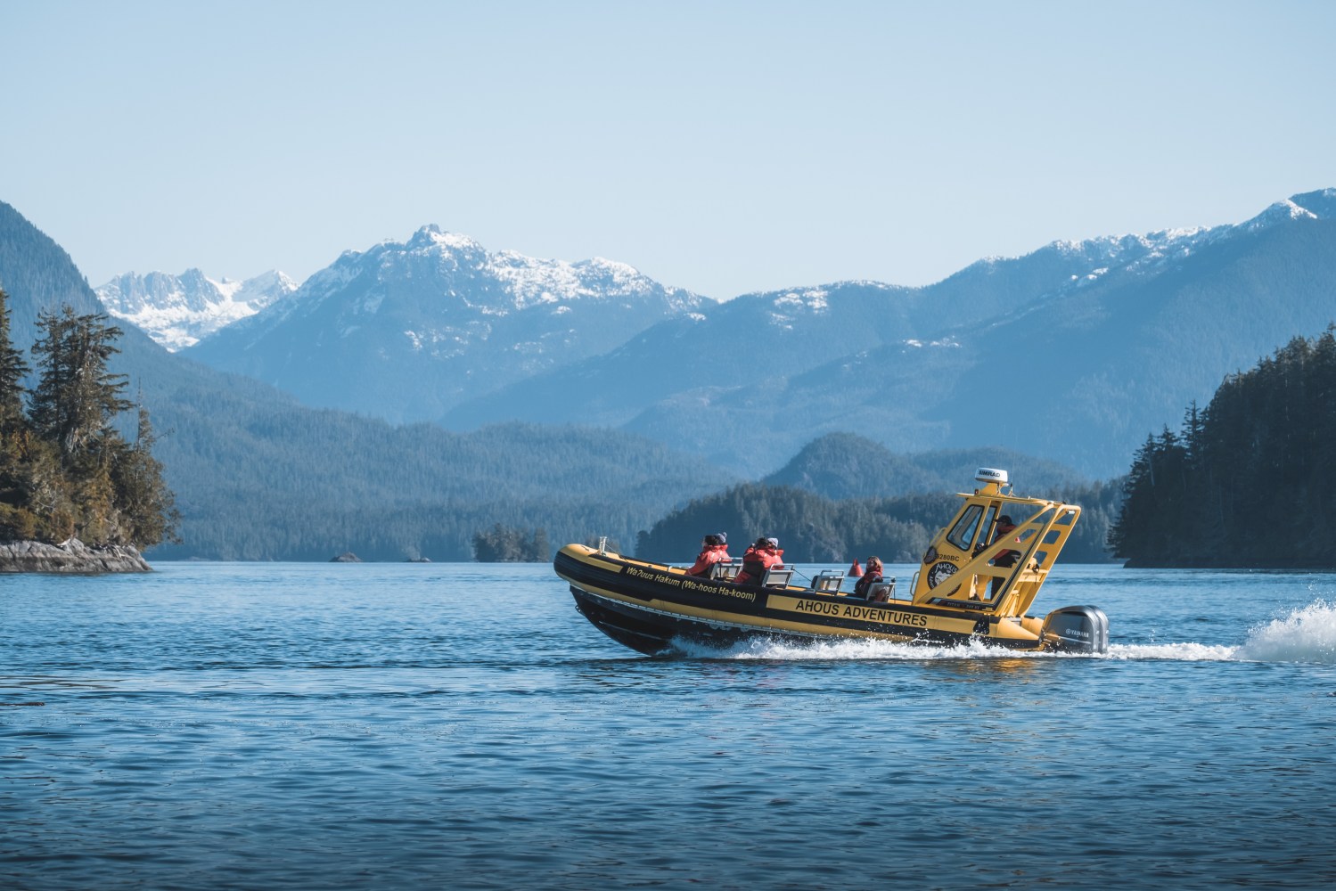 a small boat in a body of water with a mountain in the background